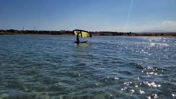 Wing foil student in clear shallow water
