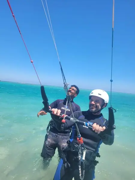 Instructor helping a guest hold the kite bar
