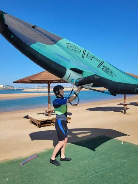 Guest lifting a wing on the beach