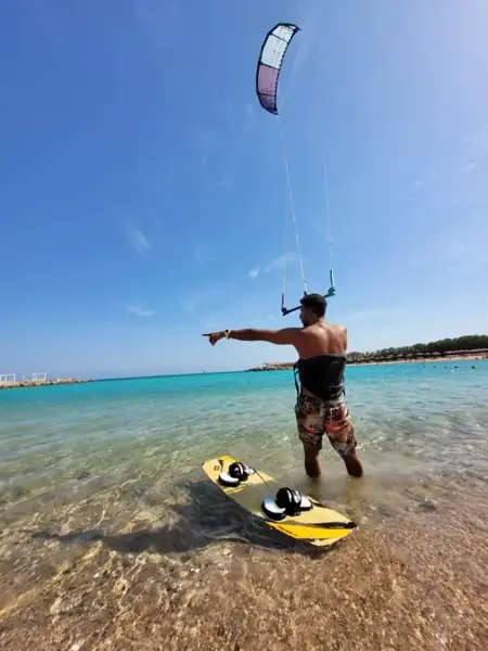 Instructor flying a kite and pointing to the sea