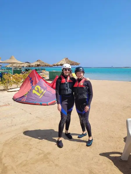 Two guests ready for their lesson in wetsuits and vests