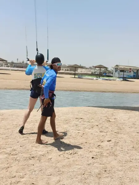 Instructor guiding a guest flying a kite